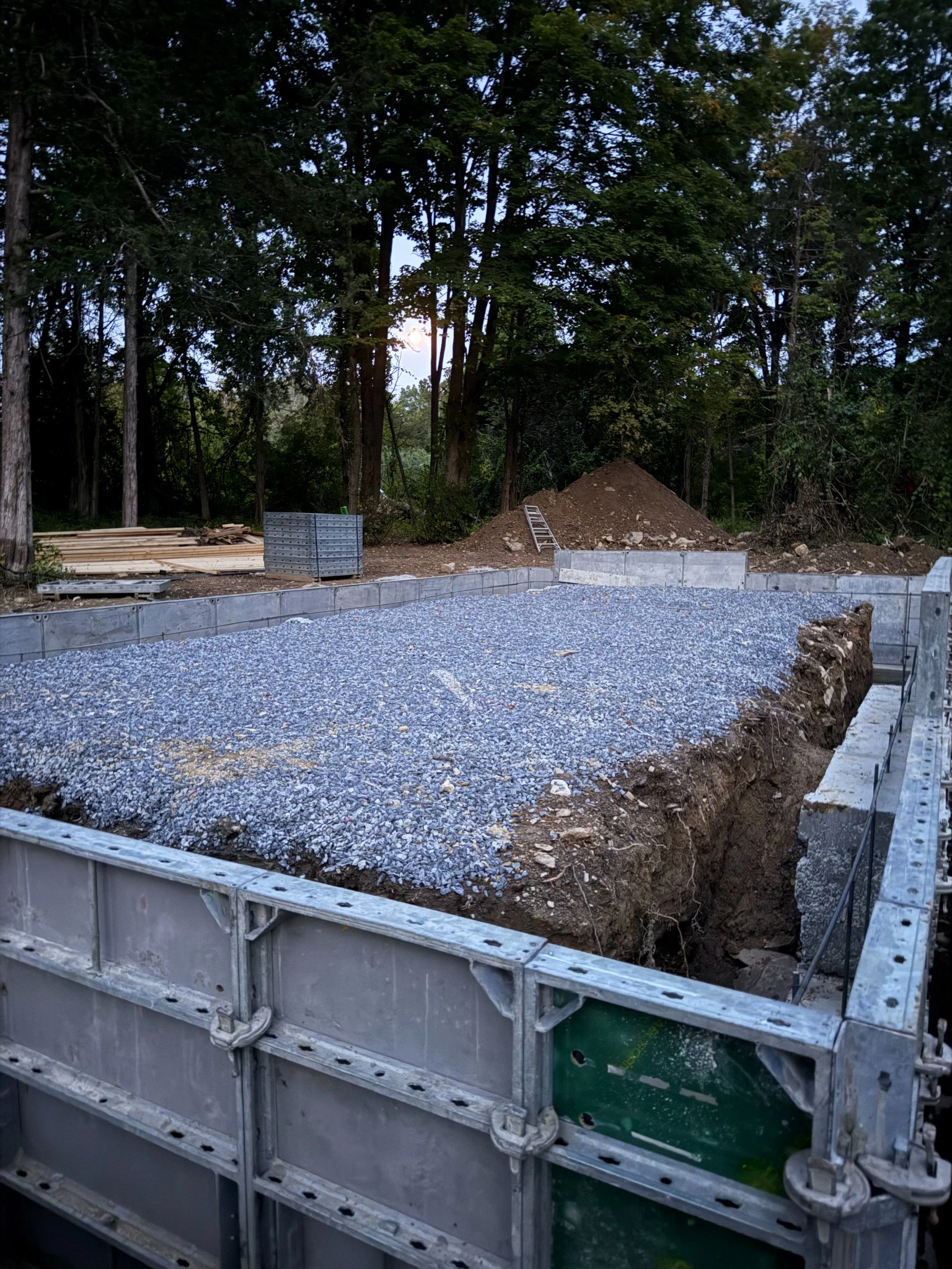 Concrete foundation forms filled with gravel at construction site