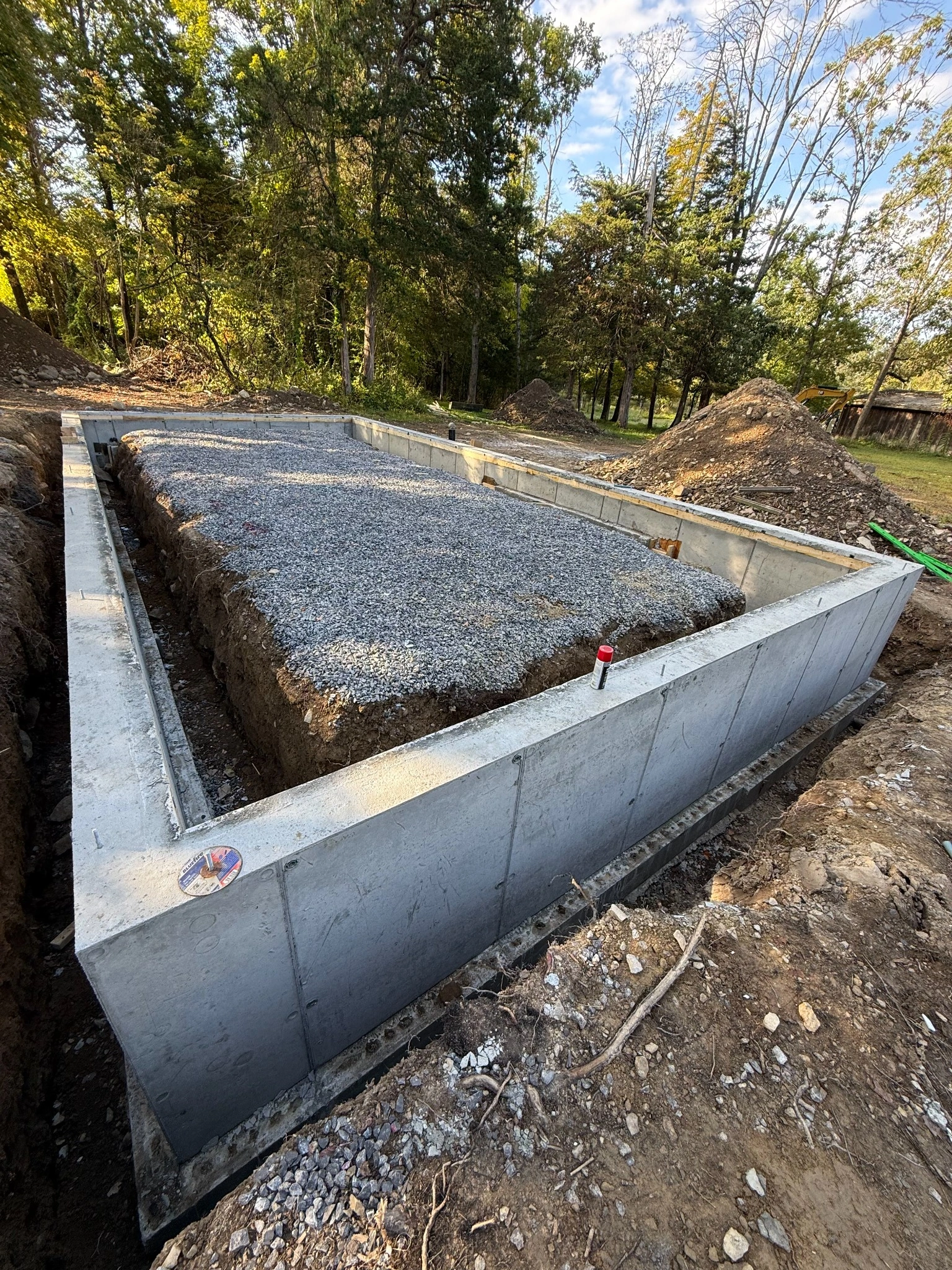 Concrete slab foundation with wood framing underway at rural construction site